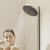 Pommeau de douche Grohe, rond, finition chromée, installé sur carrelage blanc.