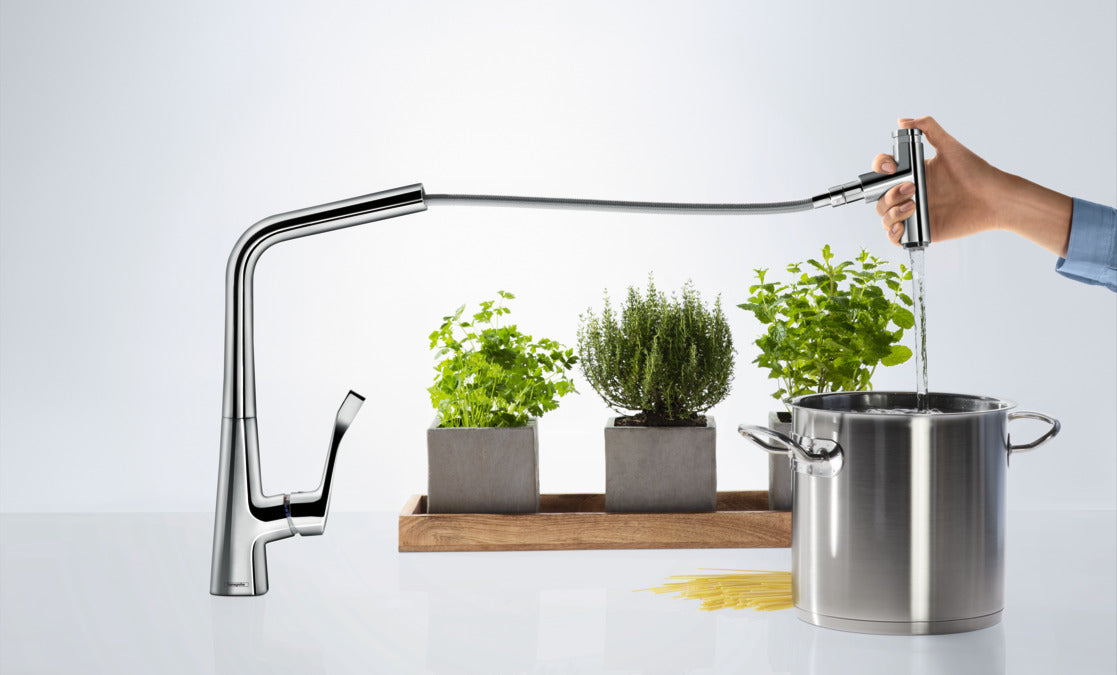 Mitigeur de cuisine Grohe chromé, robinet extensible, eau versée dans une casserole.