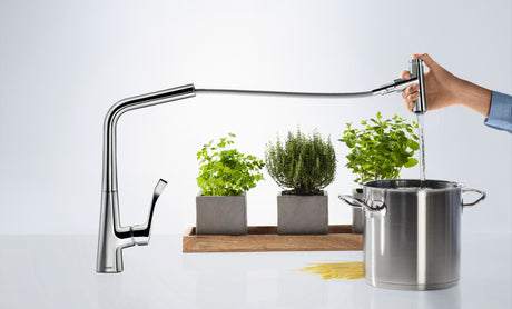 Mitigeur de cuisine Grohe chromé, robinet extensible, eau versée dans une casserole.