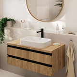 Meuble vasque de salle de bain bois clair, robinet noir, marque non visible.