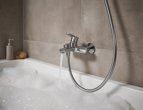 Mitigeur de baignoire Grohe, robinet chromé, couleur argent, installé sur carrelage beige.