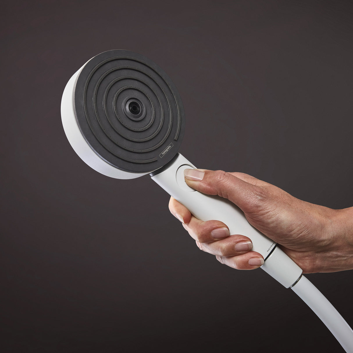 Douchette Grohe, pommeau de douche rond, couleur noire et blanche, tenue en main.