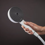 Douchette Grohe, pommeau de douche rond, couleur noire et blanche, tenue en main.