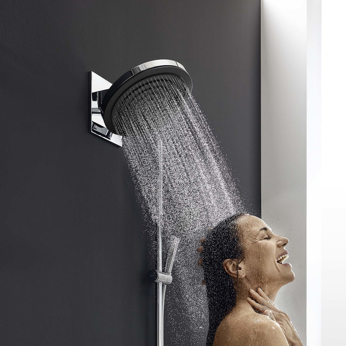 Douche Grohe, colonne de douche chromée, femme appréciant l'eau sous pommeau rond, salle de bain moderne.