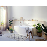 Baignoire rectangulaire blanche de la marque Hansgrohe dans une salle de bain moderne lumineuse, entourée de plantes vertes.