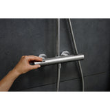 Mitigeur de douche thermostatique Grohe, chrome, sur mur sombre, main réglant le robinet