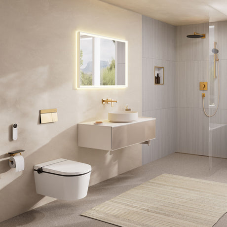 Salle de bain moderne avec WC suspendu blanc Grohe, robinetterie dorée, vasque ronde beige.