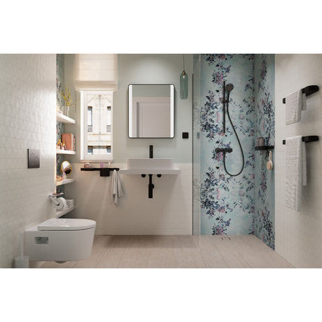 Douche Grohe noire, type mitigeur, sur fond mural floral bleu dans salle de bain moderne.