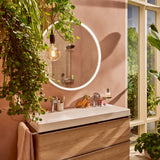 Miroir lumineux rond Grohe, meuble lavabo bois, couleur rose, salle de bain moderne