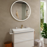 Vasque à poser blanche Jacob Delafon, robinet doré, miroir rond lumineux, meuble salle de bain moderne.