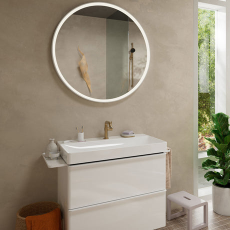 Vasque à poser blanche Jacob Delafon, robinet doré, miroir rond lumineux, meuble salle de bain moderne.