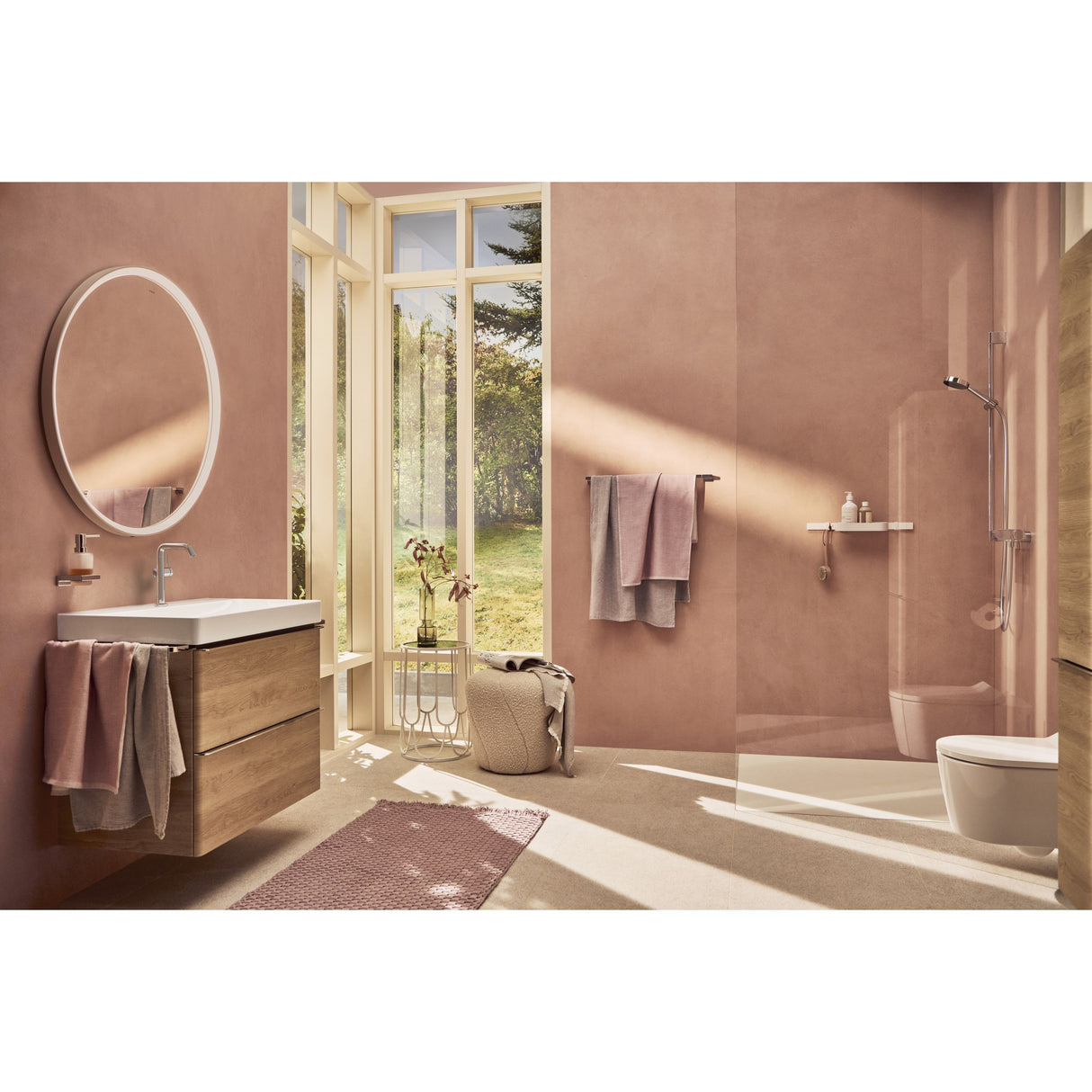 Salle de bain Grohe, ensemble meuble bois clair, douche et accessoires rose pâle.
