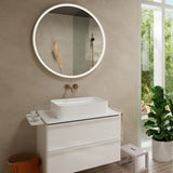 Meuble de salle de bain blanc avec vasque rectangulaire, miroir rond éclairé, robinet doré, marque non identifiable, design moderne.