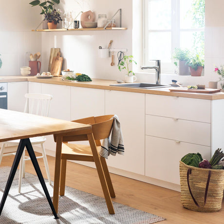 Mitigeur de cuisine chromé Grohe, robinet moderne couleur argent, installé sur évier blanc.