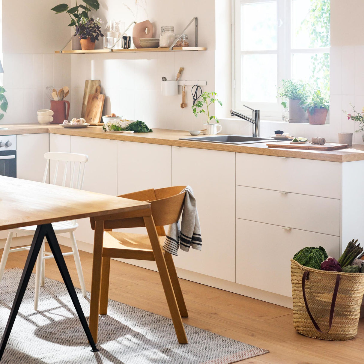 Cuisine moderne avec meuble bas blanc, plan de travail bois clair, mitigeur inox, ambiance lumineuse.