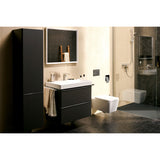 Meuble de salle de bain noir, marque Grohe, avec lavabo blanc, dans une salle de bain moderne.