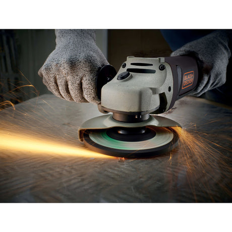 Meuleuse d’angle Black+Decker noire et grise en action, étincelles visibles.