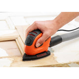 Ponceuse Black+Decker, ponceuse électrique, couleur orange et noire, en action sur du bois.