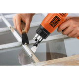 Décapeur thermique Black+Decker orange utilisé pour décaper une fenêtre bois, outillage électroportatif