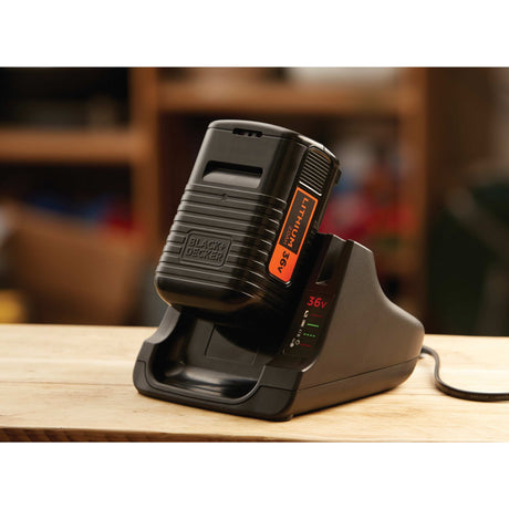 Batterie lithium noire BLACK+DECKER 36V sur chargeur, outil électroportatif.