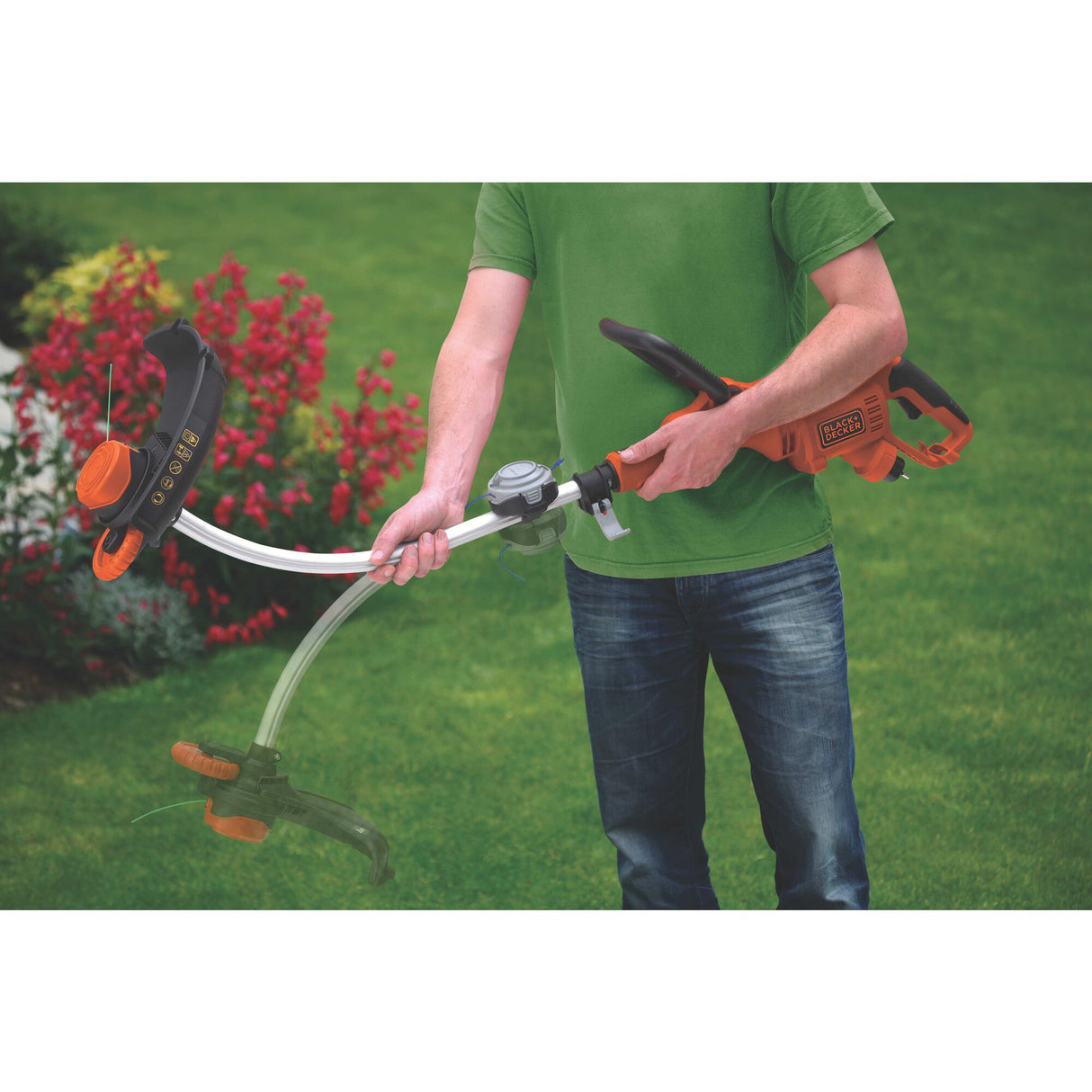 Coupe-bordure Black & Decker, outil de jardinage orange et noir en main, pelouse verte