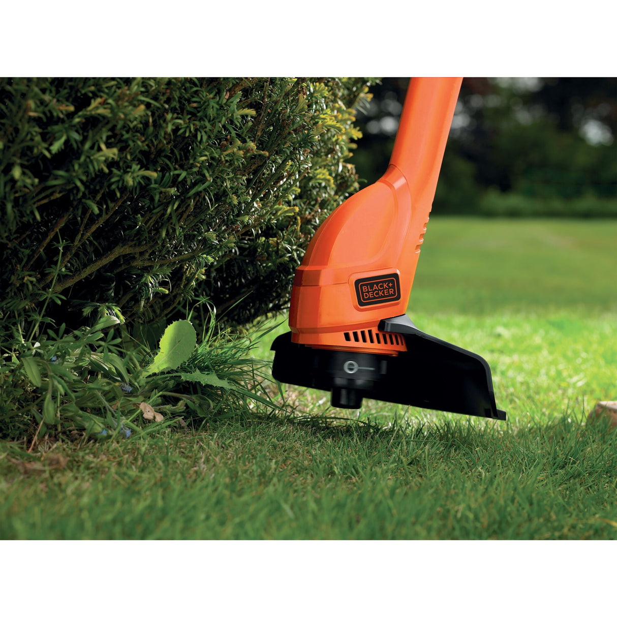 Coupe-bordures Black+Decker, outil de jardinage orange utilisé sur du gazon