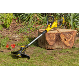 Débroussailleuse jaune Stanley, outil de jardinage, posée sur de l’herbe au soleil