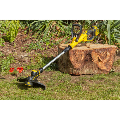 Débroussailleuse jaune Stanley, outil de jardinage, posée sur de l’herbe au soleil