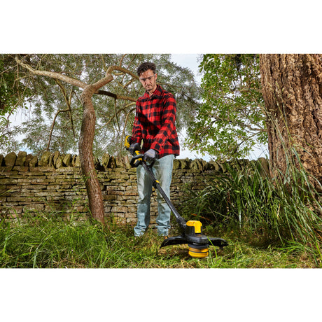 Débroussailleuse Dewalt noir et jaune, outil de jardinage, utilisée en extérieur