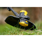 Tête de coupe de débroussailleuse DeWalt, jaune et noire, sur herbe verte