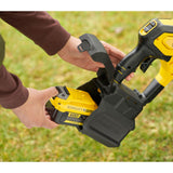 Batterie jaune Stanley Fatmax pour outil électroportatif, en main, sur fond d’herbe