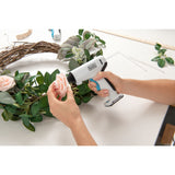 Pistolet à colle blanc Black+Decker utilisé pour coller une fleur sur une couronne de feuilles.