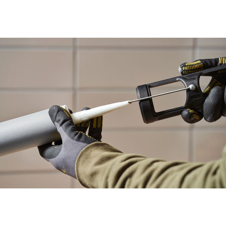 Cartouche de mastic Facom grise, pistolet à mastic noir utilisé par une personne gantée