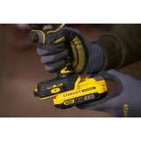 Perceuse visseuse Stanley Fatmax jaune et noire, modèle V20, en main avec des gants.