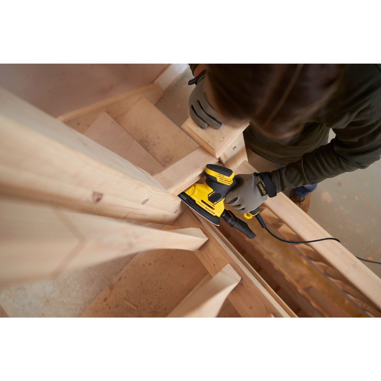ponceuse électrique Dewalt, outil électroportatif jaune, en action sur bois