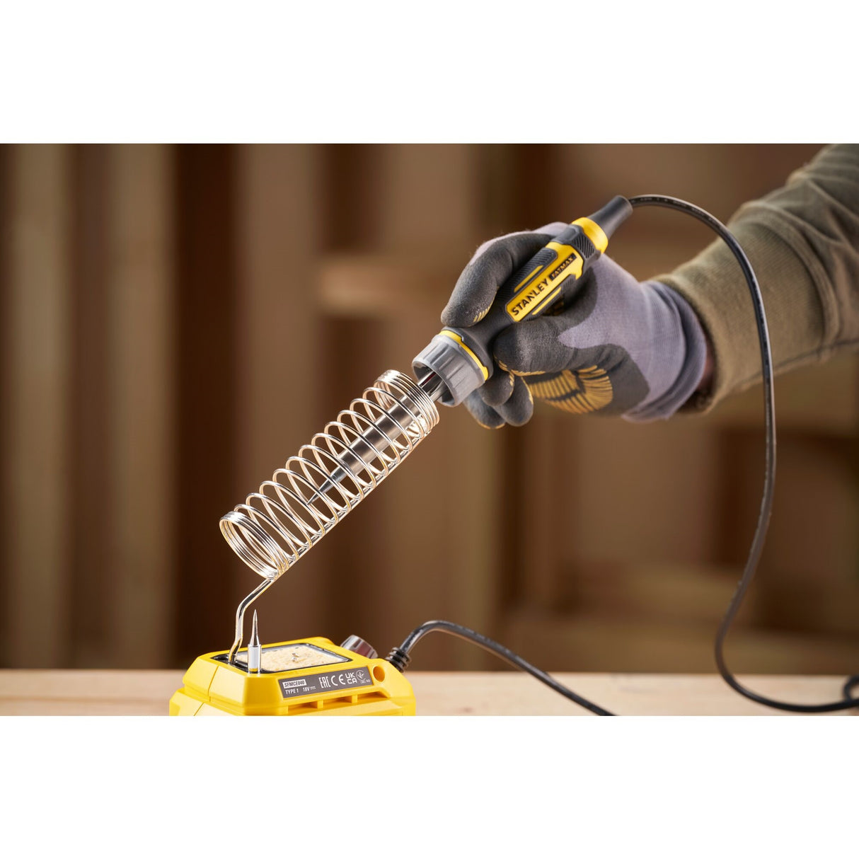 Fer à souder STANLEY, outil électrique jaune et noir, en utilisation, pour bricolage.