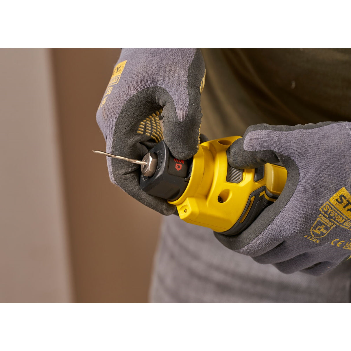 Perceuse visseuse DeWalt, outil électroportatif jaune, prise en main avec gants.
