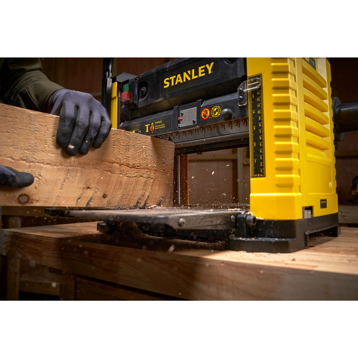 Raboteuse électrique Stanley jaune en action, machine-outil pour bois