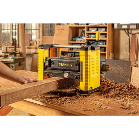 Raboteuse électrique Stanley, outillage jaune et noir, en action dans un atelier de menuiserie
