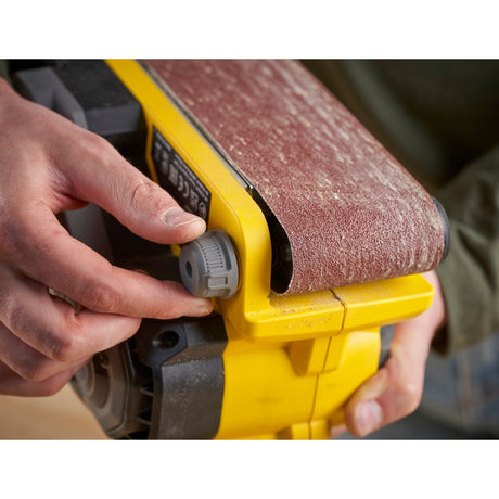 Ponçeuse à bande DeWalt jaune, outil électrique de bricolage, en réglage.