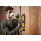 Ponceuse sans fil Stanley jaune utilisée pour poncer une porte en bois