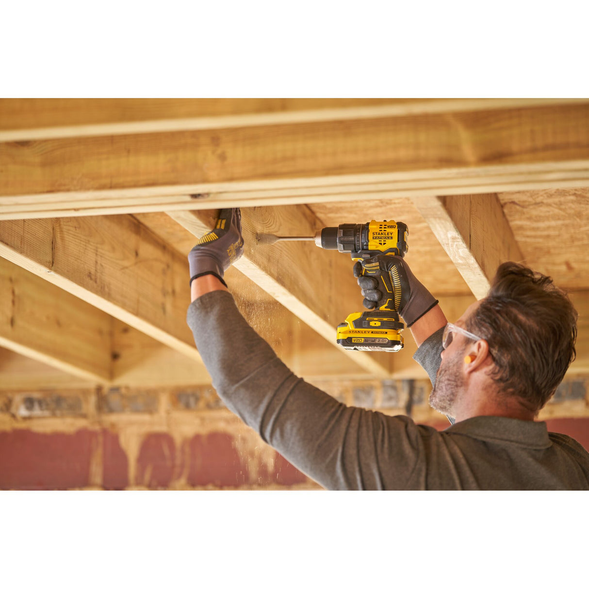 Perceuse-visseuse jaune Stanley utilisée pour percer du bois, outil électroportatif.