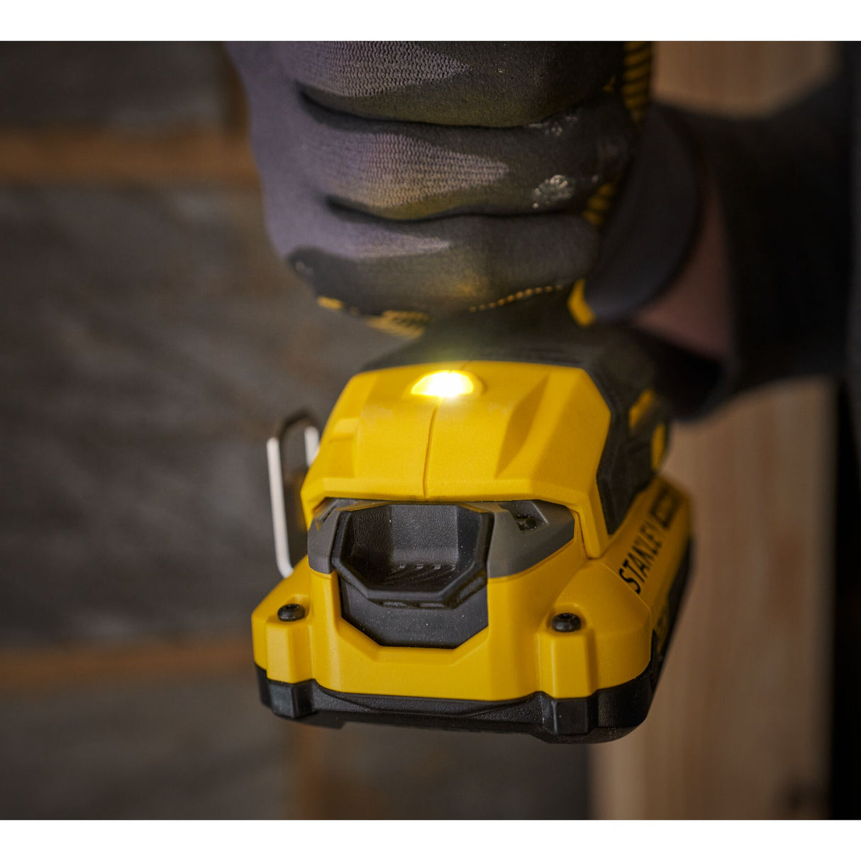 Perceuse Stanley, outil électroportatif jaune, vue en main avec LED allumée.