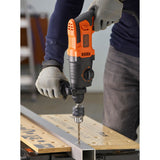 Perceuse filaire Black+Decker, outil électroportatif, couleur orange et noire, en action