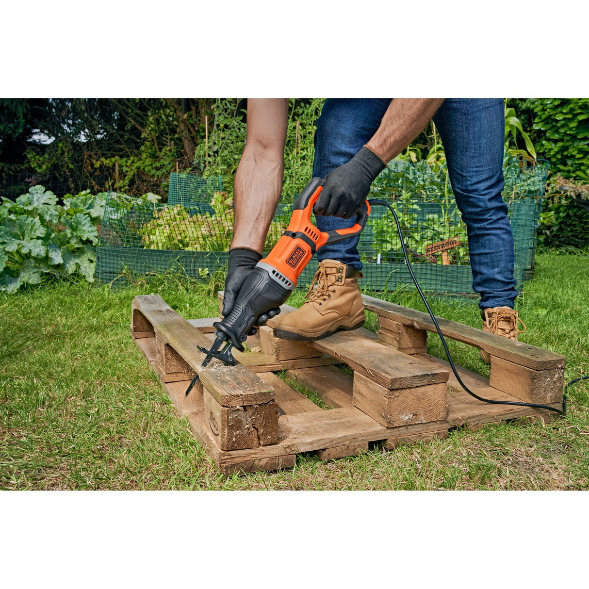 Scie sabre Black+Decker orange, outil électrique utilisé pour couper une palette en bois.