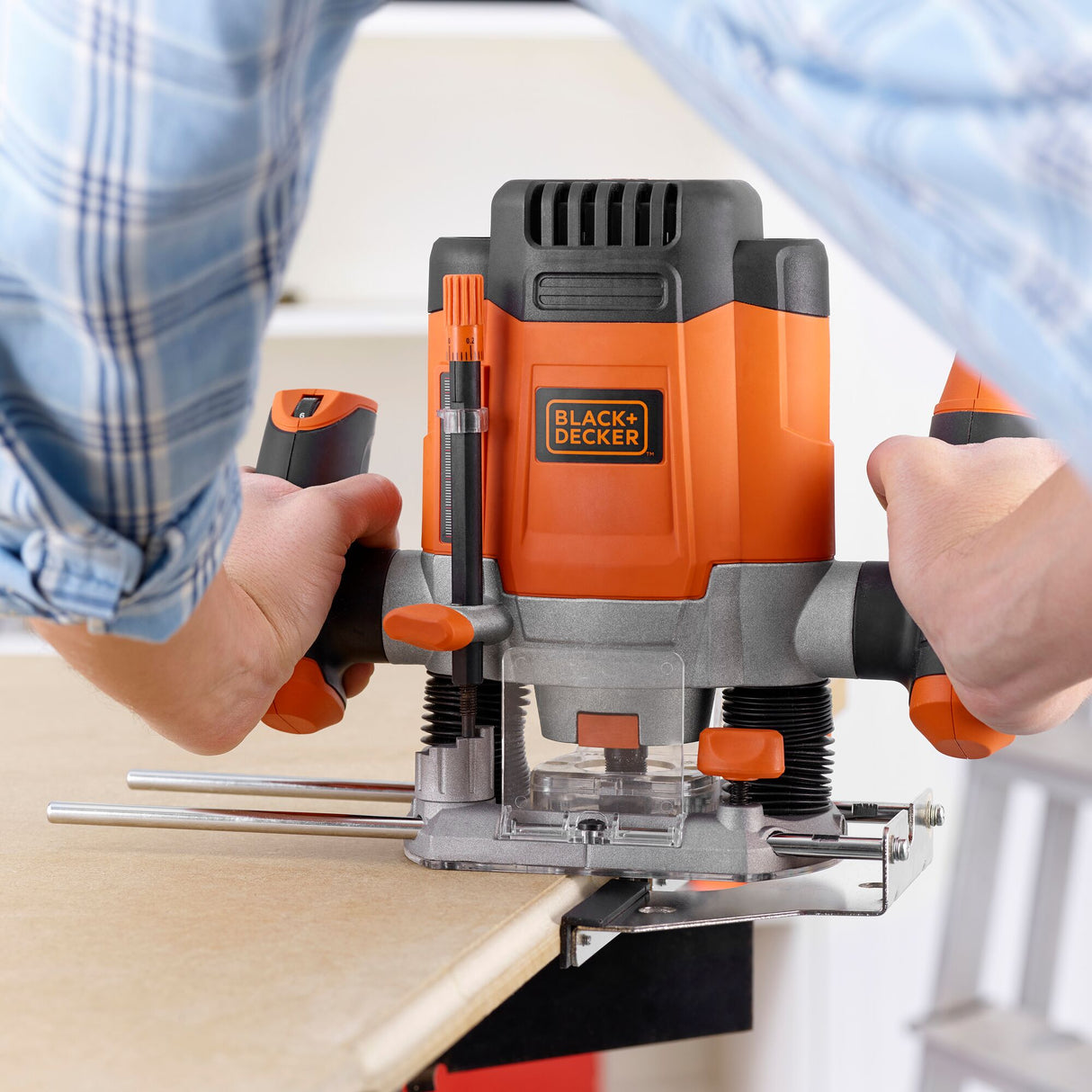 Défonceuse BLACK+DECKER, outil électroportatif orange et noir, en cours d'utilisation sur bois.