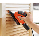 Ponceuse triangulaire noire et orange Black+Decker utilisée sur du bois clair