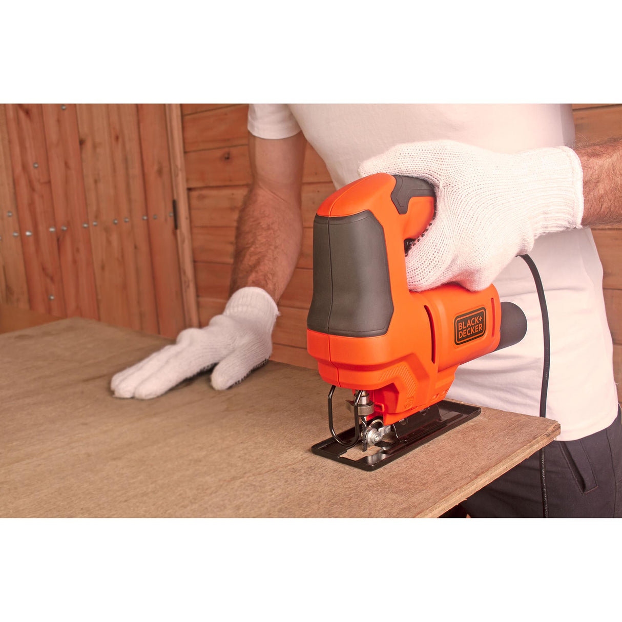 Scie sauteuse Black+Decker, outillage, orange et noir, utilisée pour couper du bois.