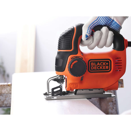 Scie sauteuse BLACK+DECKER orange en action, outil électroportatif de bricolage.