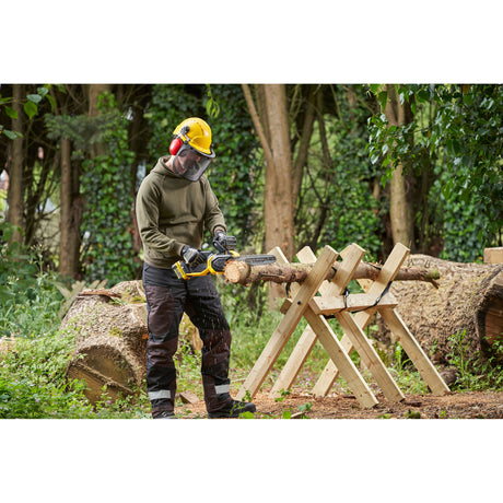 Tronçonneuse Dewalt, outil électroportatif jaune, utilisée en forêt pour couper du bois.